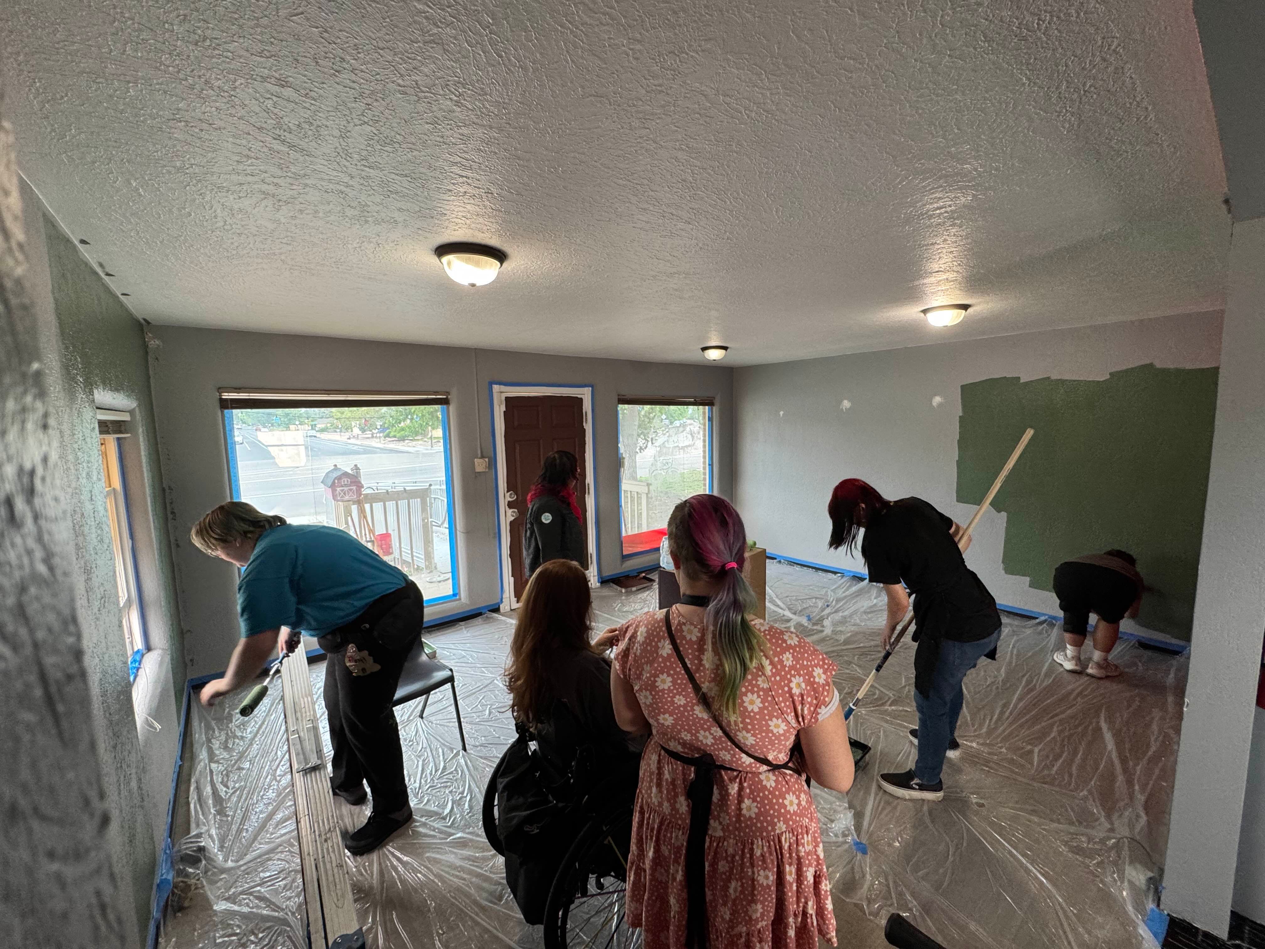 various people painting a room