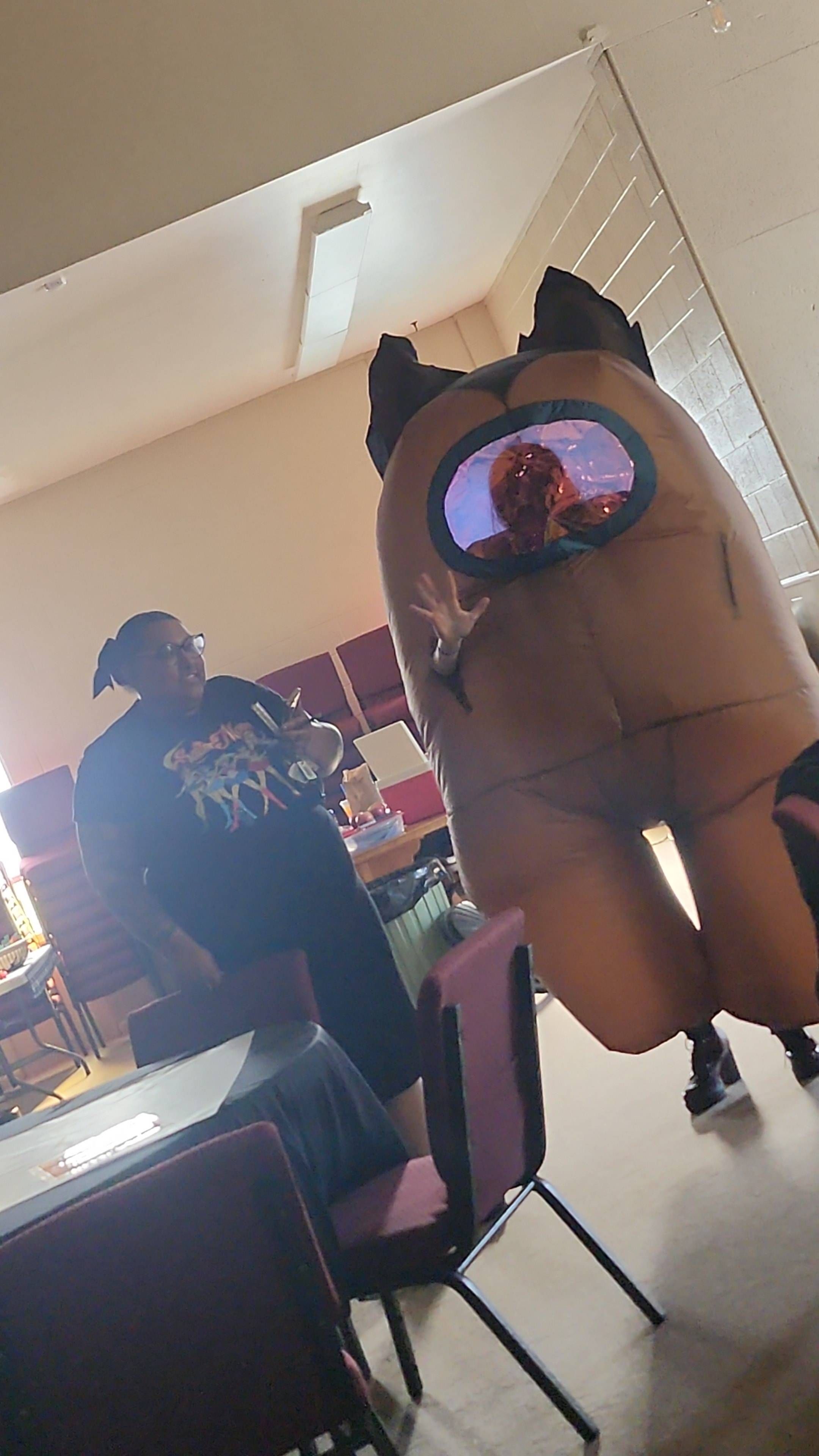 2 people standing next to eachother, one in an Among Us costume